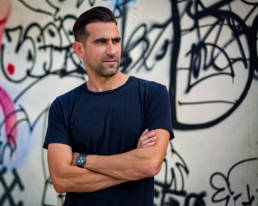 Photo of a man in front of a graffiti wall by Marcel Lecours.